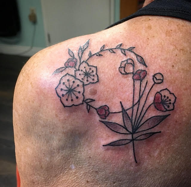 tattoo of flowers and leaves on author's shoulder